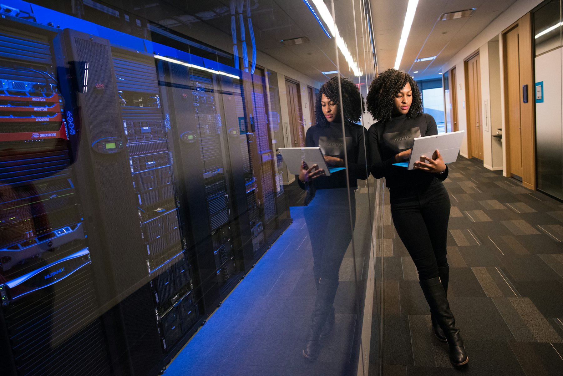 Two people walking an aisle in a data centre